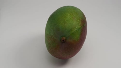 Reife Mango rotiert auf weißem Hintergrund