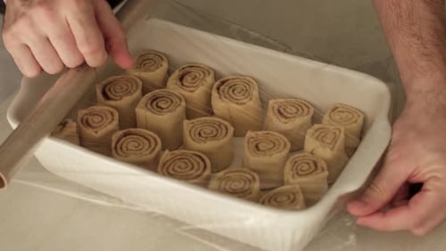 Cinnamon Rolls Covered in Plastic Wrap in Tray
