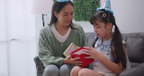 Woman and Child Opening Birthday Gift Together