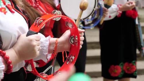 110 s. Mujeres vestidas con trajes festivos bordados tocan música nacional ucraniana en una mano antigua