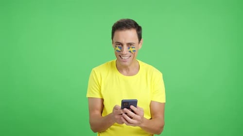 Swedish Supporter Looking at His Mobile Smiling and Showing It