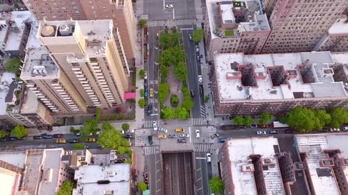 Various kinds of buildings in the district of New York. Busy streets with many cars going along.