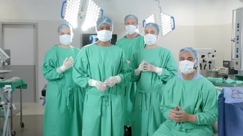 Portrait of diverse surgeons wearing surgical gowns in operating theatre, slow motion