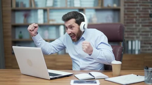 Bearded Man Video Conferencing and Celebrating at Workplace