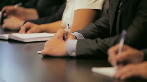 People Writing Notes at Corporate Meeting