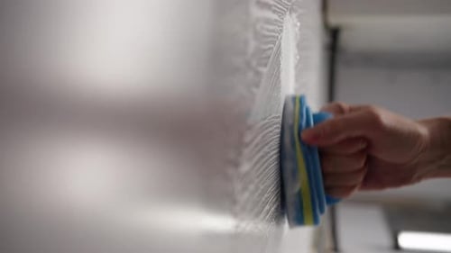 Hand Applying Foam with Blue Sponge