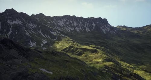 Majestic Mountain Landscape with Sunlight Illuminating Grassy Slopes