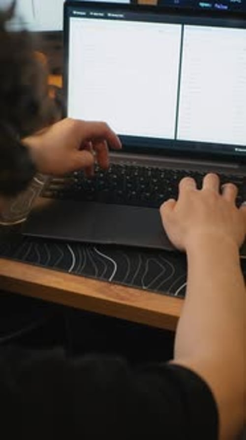 Man Coding on Laptop Computer Writing Software in Office