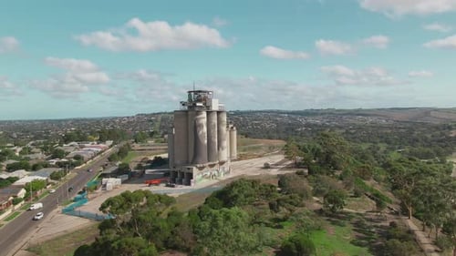 4k Aerial Painted grain silos with city in background Drone wide shot