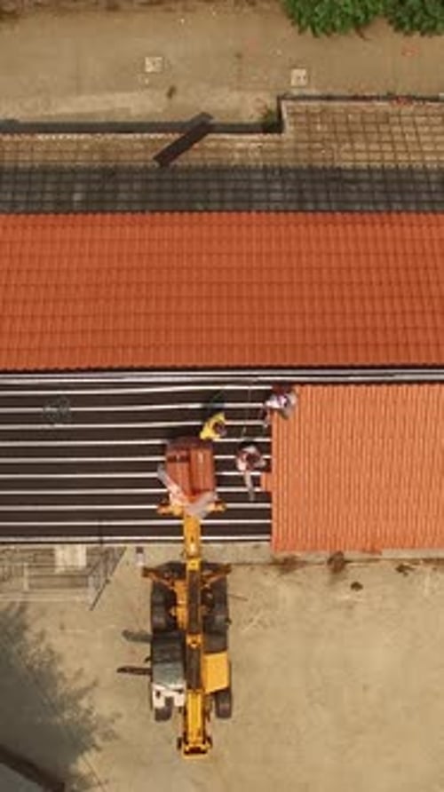 Vertical Video of Man Putting New Roof on Building