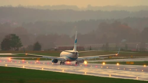 Airplane Arriving at International Airport Driving on Wet Runway on Rainy Day Travel By Air