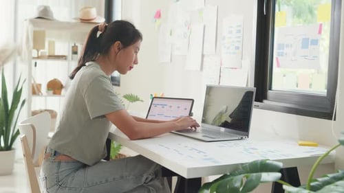 Asia girl IT development programmer typing on keyboard coding programming fixing data code.