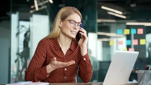 Woman Talks on Phone in Modern Workplace Office