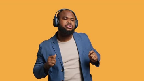 Man Having Fun Dancing on Rhythm Listening to Headphones Studio Background