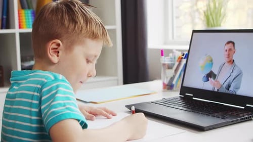 Boy Studies At Desk Watching Online Laptop Lesson