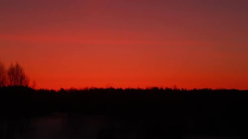 Red sunset over forest silhouette a warm evening horizon landscape