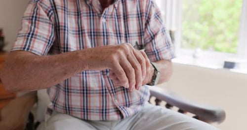 Senior Man Applying Lotion to Hands at Home