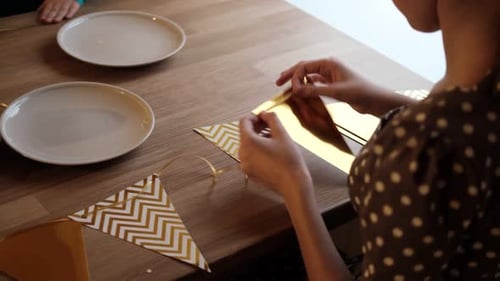Woman Making Party Banner on Wooden Table