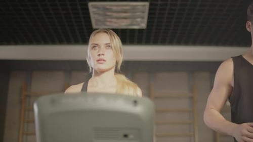 Concentrated Sport Couple Talking in Fitness Gym. Fitness Woman and Man Training