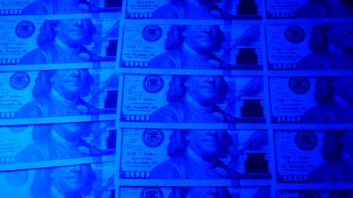Blue Lit Hundred Dollar Bills Background