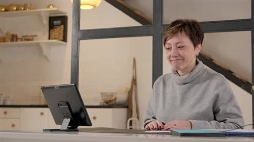 Woman Using Tablet for Video Conference Call at Home
