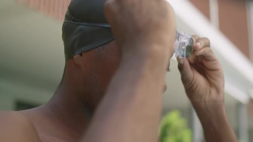 African American Swimmer Putting on Goggles