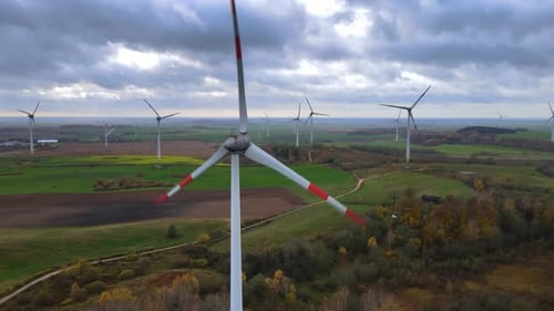 Aerial shot of group rotating wind turbines in wind farm for renewable electric power production in