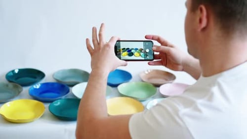 Man Photographs Colorful Ceramic Bowls and Plates
