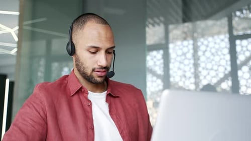 Young Man Wearing Headset Working at Computer
