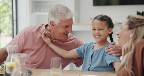 Loving Three-Generation Family Smiling at Dining Table