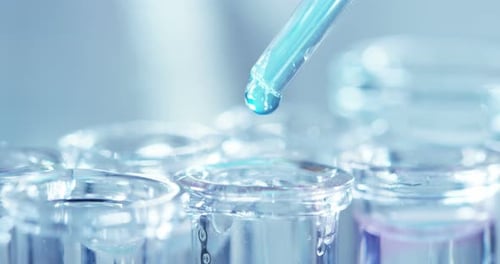 In einem Labor analysiert ein Wissenschaftler mit einer Pipette eine farbige Flüssigkeit, um DNA und Molekül zu extrahieren