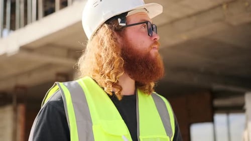 Construction worker at building site and digital tablet in hands writes notes with stylus
