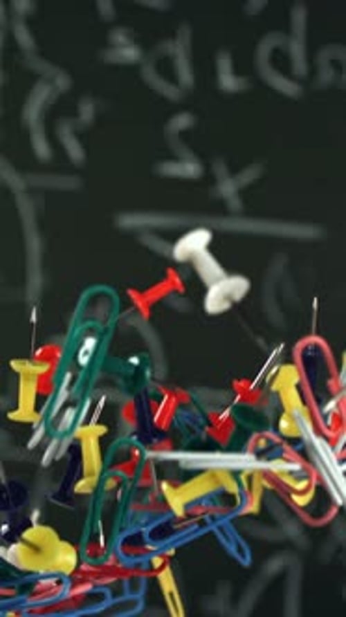 Different School Objects Fly and Fall Against the Background of the Blackboard Filmed on a Highspeed