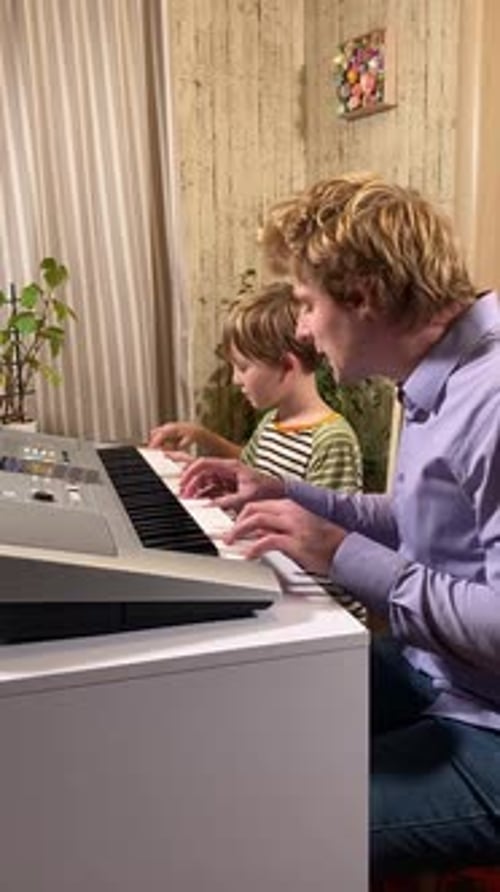 Boy and Adult Playing Keyboard Together