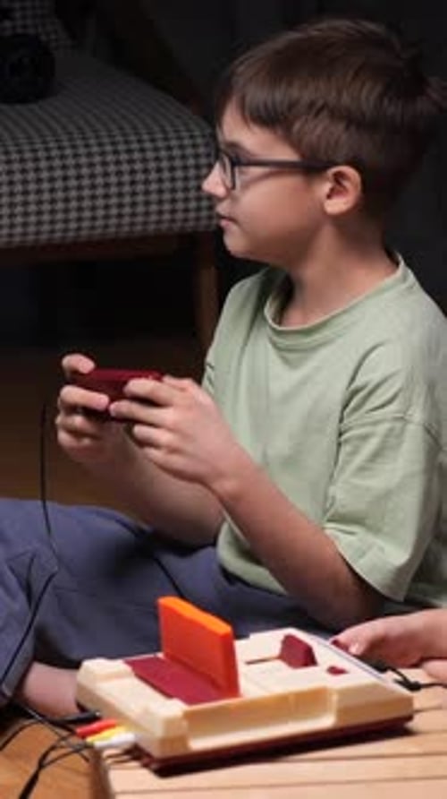 Boy Plays Retro Video Game at Home