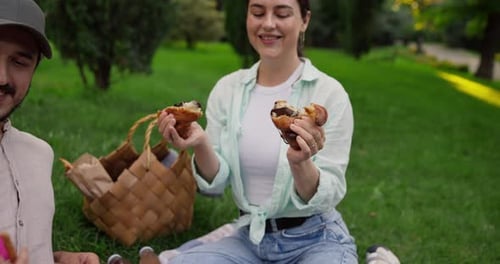 Happy Brunette Girl in Green Shirt Divides Croissant Into Two Parts From Which Chocolate Filling is