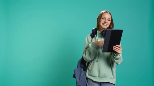 Upbeat Girl Having Fun with Mates During Internet Videocall on Tablet