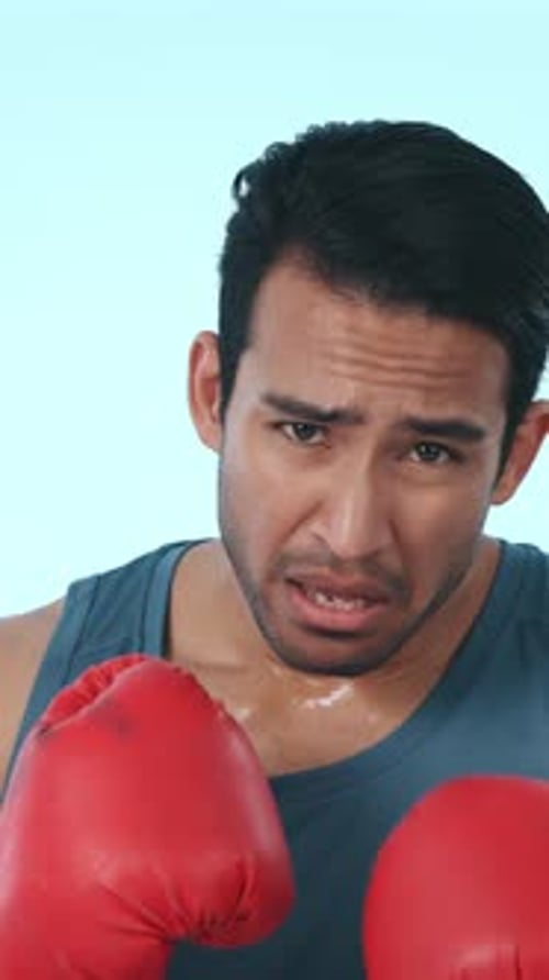 Boxe, fatigué et visage d'homme en studio avec des gants pour l'entraînement, l'exercice et la compétition intense