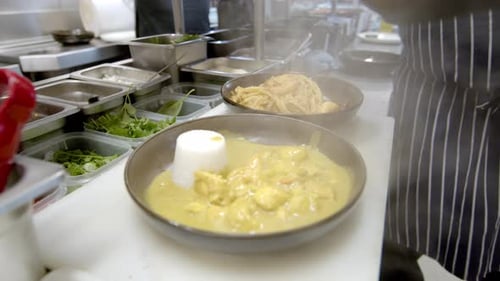 close up of chef's hand preparing curry for restaurant diners. kitchen.