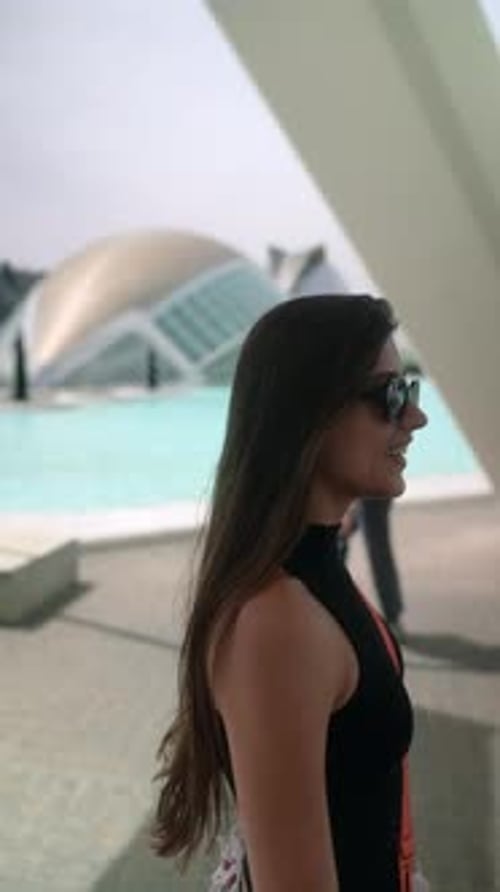 Femme souriante et élégante dans une tenue à la mode et des lunettes de soleil par une belle journée en ville
