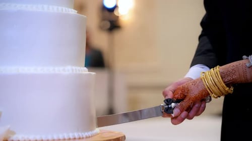 A Bride and a Groom Cutting a White Wedding Cake on the Asian Wedding Party Close Up Shot Footage