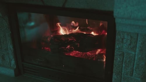 Cozy fireplace with bright burning flames at night