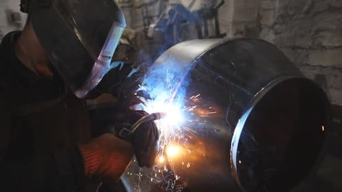 Arbeiter im Bereich Schutzmaskenschweißen, Metallbau bei industrieller Produktion, Schweißer bei der Schweißverbindung