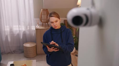 Frau installiert CCTV-Kamera mit Tablet