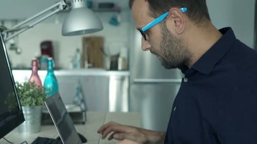 Man Typing on Laptop in Home Office