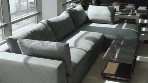 Einladende graue Eckcouch sorgt für eine gemütliche Atmosphäre im Wohnzimmer in der Nähe des Fensters