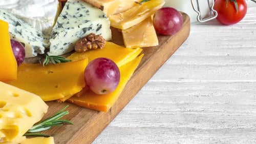 Assorted Cheeses, Grapes, and Walnuts on Cutting Board