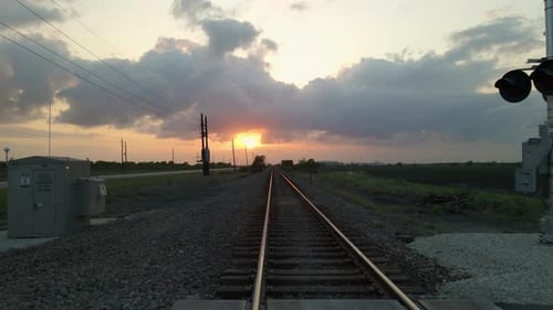 Drone Shot Passing Low Through Railroad Crossing And Following Tracks At Sunset In Texas, U.S.A.