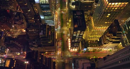 Broad street of New York going through the skyscrapers. Lots of cars move along the city