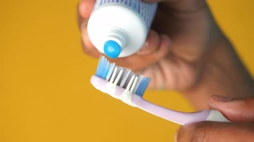 Toothpaste Being Squeezed onto Toothbrush for Dental Hygiene